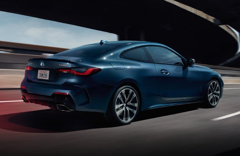 Rear view of the 2023 BMW 4 Series driving on road